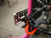 Close-up of the attachment of the Adapter Plate, sandwiching the frame, tie down and seat pan.