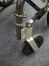 Caster wheel bolted to wheelchair frame