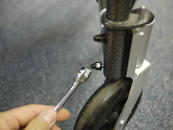 Remove bolts holding caster wheel to frame