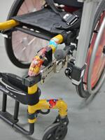 Attach a Bridge clamp to both the horizontal and vertical tube sections, on either side of the bend. Notice the use of the Adapter Plate and L-Angle Extension to move the Wheelchair Bracket to avoid interfering with the brakes.